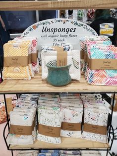 a display case filled with lots of different colored cloths on top of wooden shelves