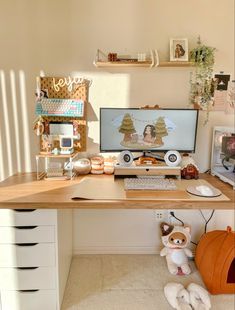 a desk with a computer and stuffed animals on it