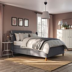 a bedroom with a bed, dressers and mirror in it's center area