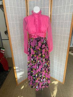 Awesome 1970’s hot pink maxi dress with pink flowers on black skirt. Long sheer sleeves, zipper up the back. One small stain on bust, rip in chiffon under one arm, and lighting discolored underarms inside the dressBust: 35/36”Waist: 28”Hips: 38”Skirt length: 38.5” Pink Maxi Dress For Spring Evening, Fall Pink Floral Print Maxi Dress, Retro Pink Floral Print Maxi Dress, Retro Fitted Pink Maxi Dress, Pink Retro Maxi Dress With Floral Print, Pink Fitted Retro Maxi Dress, Pink Long Sleeve Maxi Dress For Casual Wear, Pink Vintage Summer Maxi Dress, Pink Vintage Maxi Dress For Summer