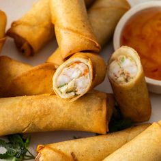 some food is laying out on a plate with dipping sauce in the bowl behind it