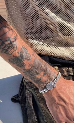 a man with tattoos on his arm and wrist