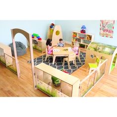 two children playing in a play room with wooden furniture and toys on the hardwood floor