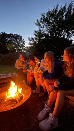 people sitting around a fire pit at night