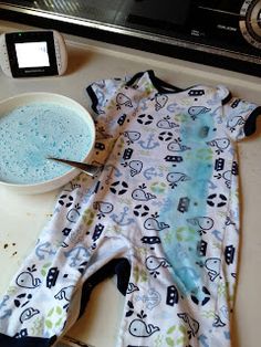 a baby romper laying on top of a counter next to a bowl of food