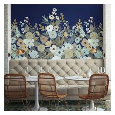 a floral wall mural in a restaurant with three chairs and two tables on the floor