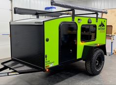 an off - road vehicle is parked in a garage with its doors open and lights on