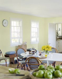 a kitchen filled with lots of furniture and green apples on top of a wooden table