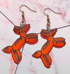 an image of orange bird earrings on marble background