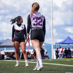 two female soccer players walking on the field