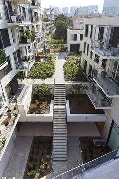 an aerial view of some buildings with plants growing in the ground and stairs leading up to them