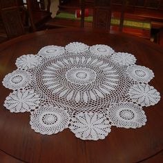 a white doily sitting on top of a wooden table