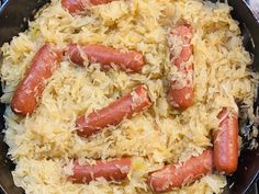 hot dogs and sauerkraut are being cooked in a skillet