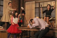 a group of people standing and sitting around a table with brooms in their hands