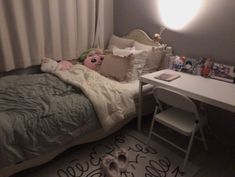 a small child's bedroom with an unmade bed, desk and toys on the floor