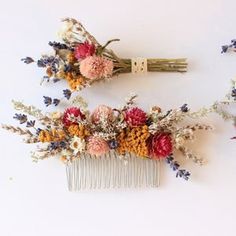 two combs with flowers on them sitting next to each other in front of a white wall