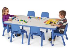 two children sitting at a table playing with toys