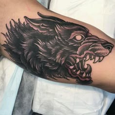 a man's arm with a black and grey tattoo of a lion on it