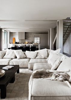 a living room filled with white couches and lots of pillows on top of it