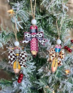 three ornaments are hanging from a christmas tree