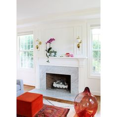 a living room with a fire place and rugs on the floor in front of it