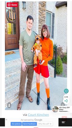 a man and woman standing in front of a house with a dog on their lap