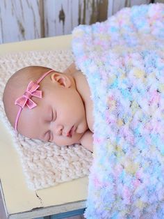 a baby sleeping on top of a crocheted blanket