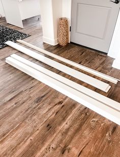 there are three pieces of wood laying on the floor in front of the door frame