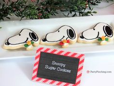 decorated cookies with snoopy dogs on them are sitting in front of a sign that says shopp sugar cookies