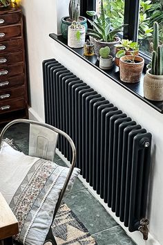 a radiator in the corner of a room with potted plants