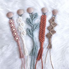 four tassels with different colors and designs on top of a white furnishing