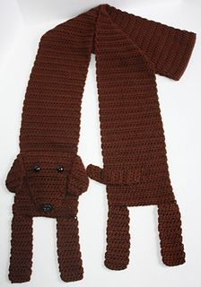 a brown knitted scarf with a dog on the front and side, sitting next to it's owner