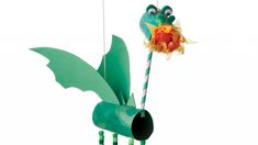 a green birdhouse with an orange flower in it's beak