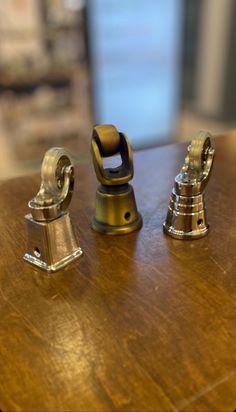 three metal objects sitting on top of a wooden table