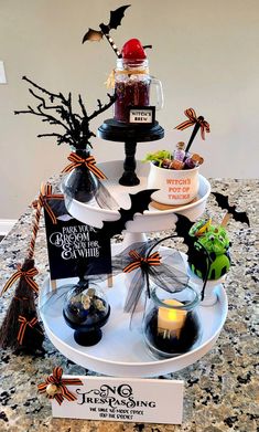 a three tiered halloween cake stand with candles and candies on it, decorated for halloween