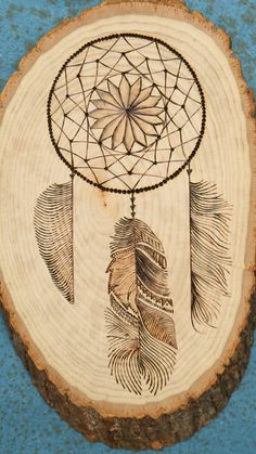 a piece of wood with an image of a dream catcher on it's side