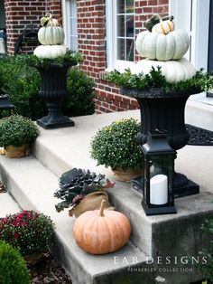 pumpkins and gourds are sitting on the steps in front of a house