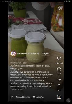 two jars filled with green liquid sitting on top of a wooden table next to a plant