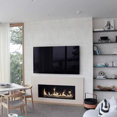 a living room filled with furniture and a flat screen tv mounted above a fire place