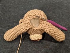 a crocheted stuffed animal with a needle in it's mouth