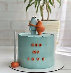 a blue cake with two cartoon characters on top and the words bd my love spelled in small letters