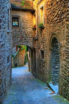 an alley way with cobblestone buildings on both sides and stone walkways between them