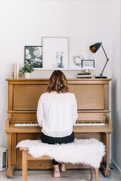 a woman sitting at a piano playing the piano