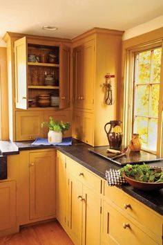 a kitchen with wooden cabinets and black counter tops