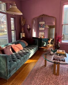 a living room filled with furniture and a glass table in front of a large window