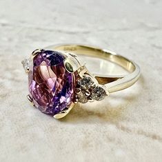 A stunning 14 karat yellow gold cocktail ring set with an oval amethyst weighing approximately 2 carat. Amethyst is the birthstone for February. It is shouldered by 6 round diamonds weighing approximately 0.20 carat (G-H SI1-I1). This ring is a size 4.75 US / J UK. > Resizing not included. This ring can be resized to fit most fingers. Please contact us for details. Resized rings are final sale. It weighs 3 grams. Birthstone: February/April. Condition: Very Good. Faint scratches throughout metal. Oval Amethyst Ring, Yellow Gold Cocktail Ring, Amethyst And Diamond Ring, Diamond Solitaire Ring, Gold Cocktail Ring, Gold Cocktail, Birthday Ring, Purple Band, Birthstone Gifts