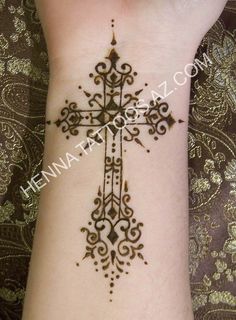 a woman's arm with a cross tattoo on it