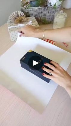 a woman is cutting paper on top of a table