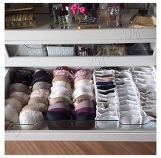 an open drawer with many pairs of shoes on it and other items in the bottom shelf