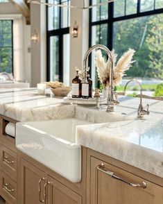 a large kitchen with marble counter tops and wooden cabinets, along with two sinks in the center